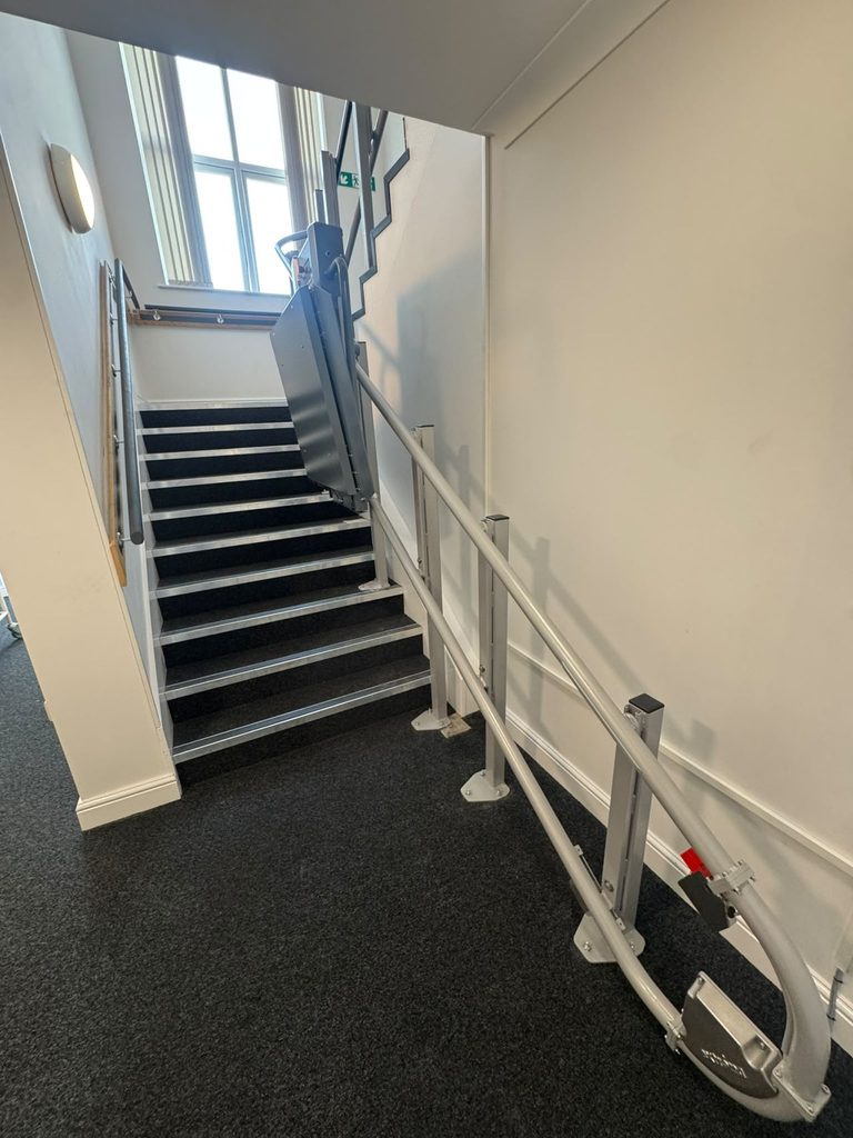 Folded incline platform lift at the bottom of a staircase